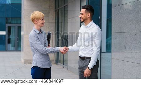 Two Multiethnic Colleagues Arab Man And Caucasian Woman Business Partners Handshaking Outdoors Near 