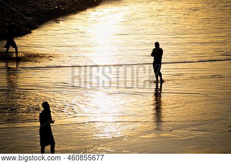 People Walking E Se Divertindo On The Sand Of Beach In The Late Afternoon.
