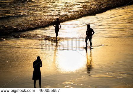 People Walking E Se Divertindo On The Sand Of Beach In The Late Afternoon.