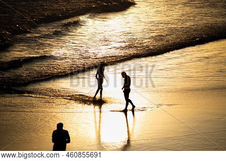People Walking E Se Divertindo On The Sand Of Beach In The Late Afternoon.