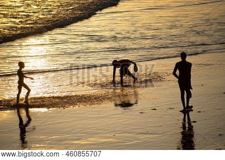 People Walking E Se Divertindo On The Sand Of Beach In The Late Afternoon.