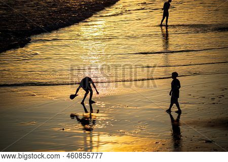 Young People Playing Frescoboll Against Sunset At Beach