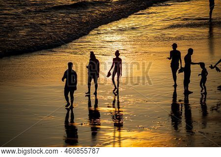 People Walking E Se Divertindo On The Sand Of Beach In The Late Afternoon.