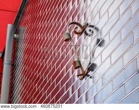 Forged Flag Holder, Twisted And Casting Shadow On A Dark Red Wall Forming A Heart Shape