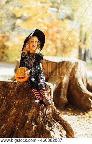 Beautiful Girl Witch. Little Girl In Witch Costume Celebrate Halloween Outdoor And Have Fun. Kids Tr