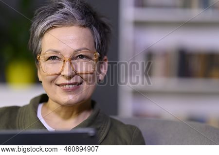 Attractive Mature Woman Looking Above Of Camera In Library Or Office. Happy Middle Aged Businesswoma