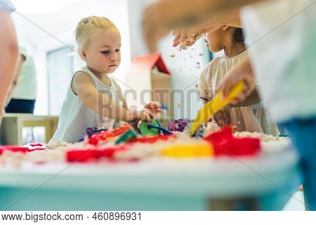 Creative Sensory Play With Moldable And Fluffy Kinetic Sand At Nursery School. Toddlers Standing Aro