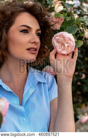 Portrait Of A Young Woman In Spring. Flowers Of Pink Roses Bloom.