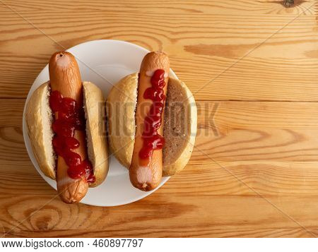 Boiled Sausage With A Bun On A Wooden Background.