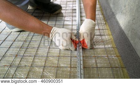 Floor Soundproofing. Close-up Of Gloved Hands Fixing Beacons On The Floor. Installation Of Building 
