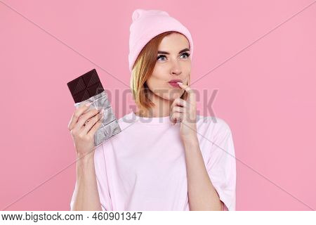 Blonde Woman In T-shirt And Hat Holding Chocolate Bar