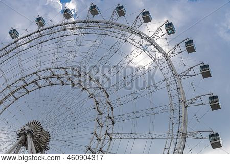 Fragment Of Ferris Wheel Booths Without People. Ferris Wheel In An Amusement Park Against The Blue S
