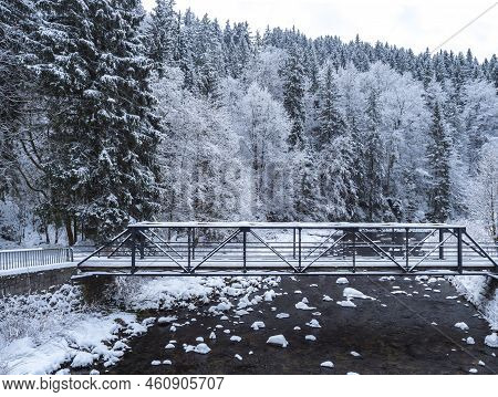 Snow-covered Pedestrian Bridge Over Elbe Or Labe River And Spruce Tree Forest At Ski Resort Spindler