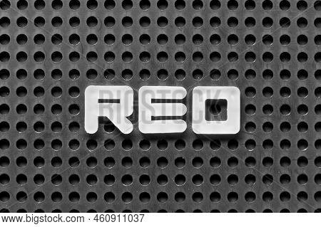 White Alphabet Letter In Word Reo (abbreviation Of Real Estate Owned) On Black Pegboard Background