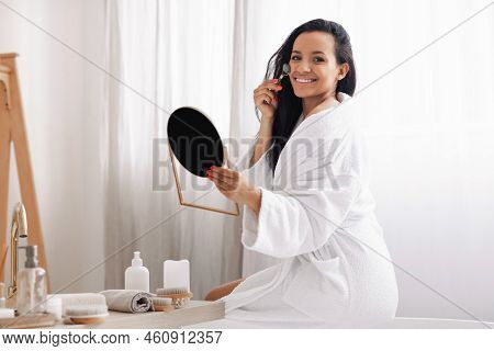 Lady Massaging Face With Stone Roller Caring For Skin Indoors
