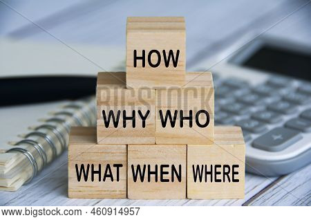 How, Why, Who, What, When And Where Text On Wooden Blocks With Calculator, Pen And Notebook Backgrou