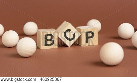 Wooden Cubes With Word Bcp On Brown Background. Front View