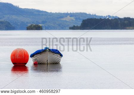 Empty Rowing Boat Floating On Lake At Loch Lomond Scotland. Calm Serene Landscape Image Of A Wooden 