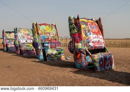 Amarillo, Texas, United States - May 2, 2022: Graffiti Covered Cars Buried Nose First In The Dirt At