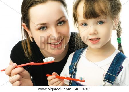 Mãe ensinando sua filha escovando os dentes