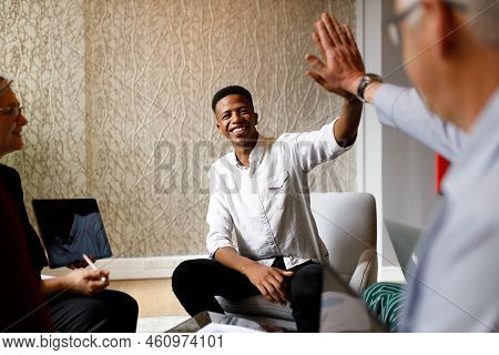 Businessman Giving A High Five To A Colleague In Meeting