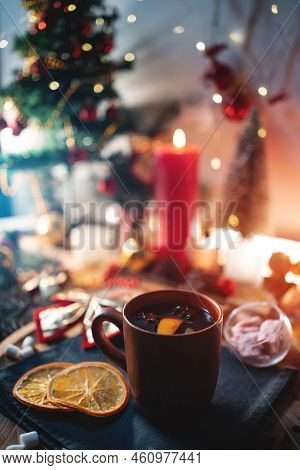 Mulled Red Wine Gluhwine In Cup With Orange, Christmas Decor Table With Candles