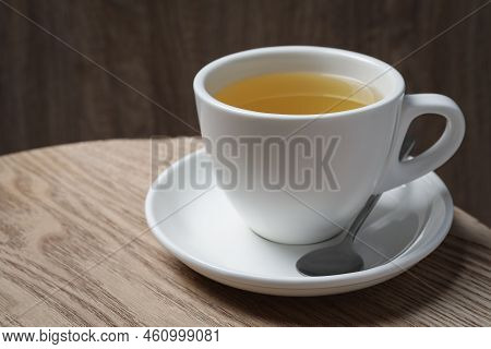 Cup Of Aromatic Buckwheat Tea And Spoon On Wooden Table