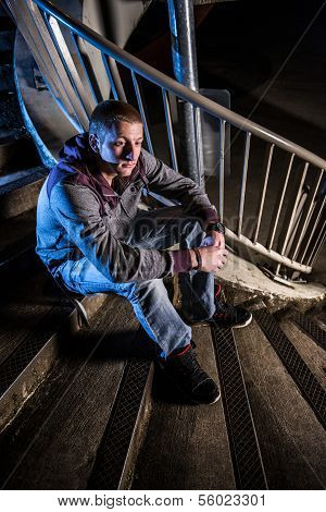 Young Man Sitting On Urban Stairs At Night