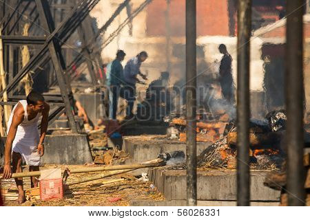 KATHMANDU, NEPAL - DEC 3: Unidentified local people during the cremation ceremony along the holy Bagmati River in Bhasmeshvar Ghat at Pashupatinath temple, Dec 3, 2013 in Kathmandu, Nepal.