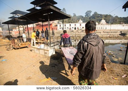 KATHMANDU, NEPAL - DEC 3: Unidentified local people during the cremation ceremony along the holy Bagmati River in Bhasmeshvar Ghat at Pashupatinath temple, Dec 3, 2013 in Kathmandu, Nepal.