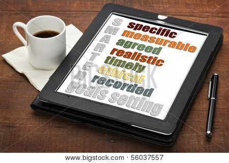 SMARTER (specific, measurable, agreed, realistic, timely, ethical,  recorded) goal setting concept  on a digital tablet computer with  espresso coffee