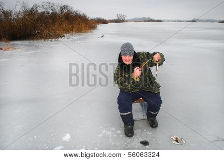 Winter Fisherman On The River Catching Fish