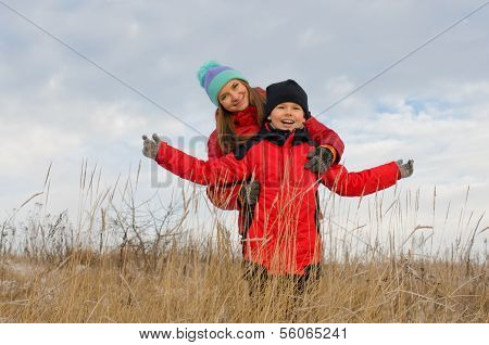 Laughing children together outdoors in winter.