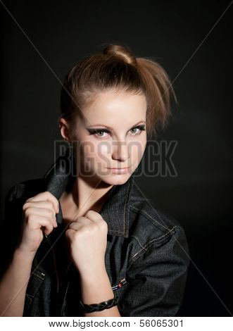 Young attractive fashion model posing on dark background.