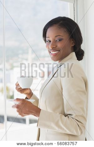 Portrait of an elegant young smiling businesswoman with a cup of tea in the office