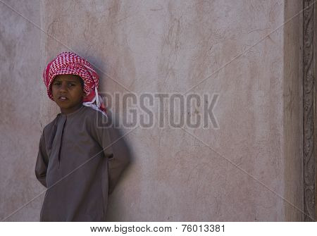 Young Omani Boy Standing On A Wall.