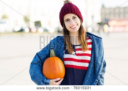 Young woman holding a pumpkin
