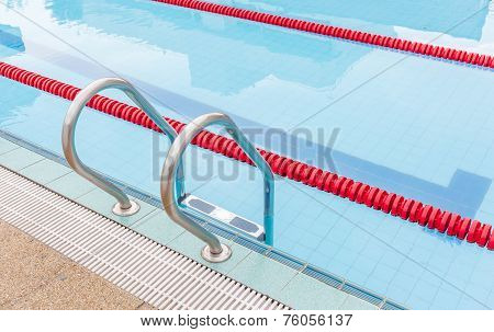 The View Of Metallic Ladder Of Swimming Pool With Marked Lanes.