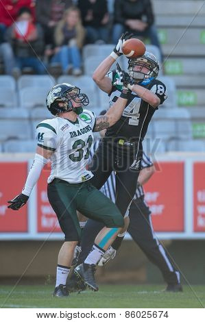 INNSBRUCK, AUSTRIA - MARCH 29, 2014: CB Christian Kober (#31 Dragons) and WR Clemens Erlsbacher (#84 Raiders) fight for the ball in an AFL football game.