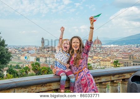 Happy Mother And Baby Girl With Flag Rejoicing Against Panoramic
