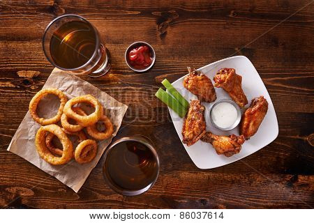 appetizer sampler with onion rings and chicken wings shot top down