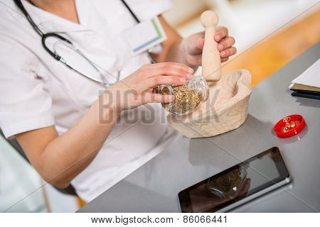 Woman doctor using a mortar and pestle