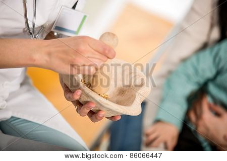 Woman doctor using a mortar and pestle
