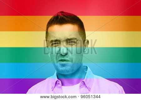 homosexual, homophobia, intolerance and people concept - gay man wrying over rainbow flag background