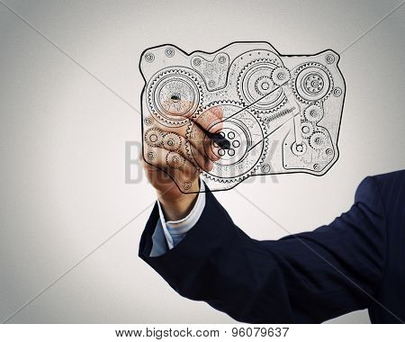 Close up of hand darwing gear mechanism with marker