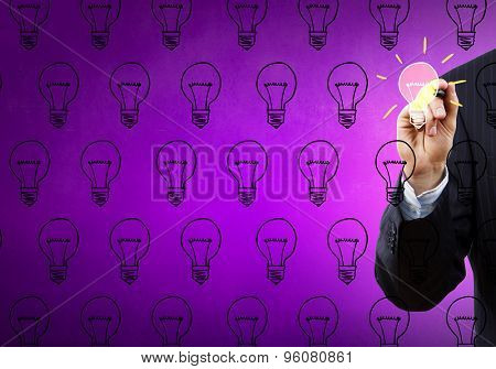 Close up of hand darwing light bulb with marker