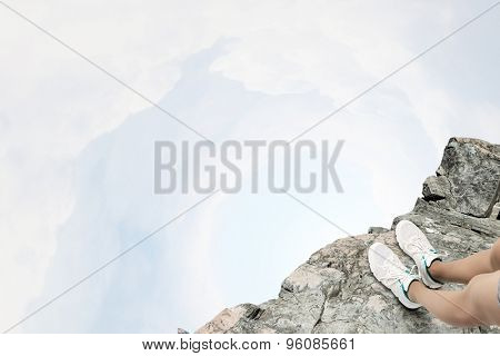 Close up of woman legs standing on the edge of rock