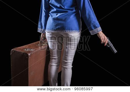 Women with Islamic headscarf subject suitcase and gun