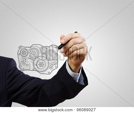 Close up of hand darwing gear mechanism with marker
