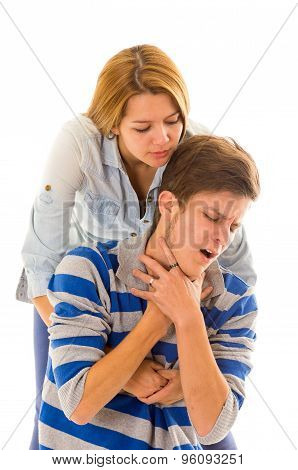 Couple demonstrating first aid techniques with woman performing heimlich in male choking